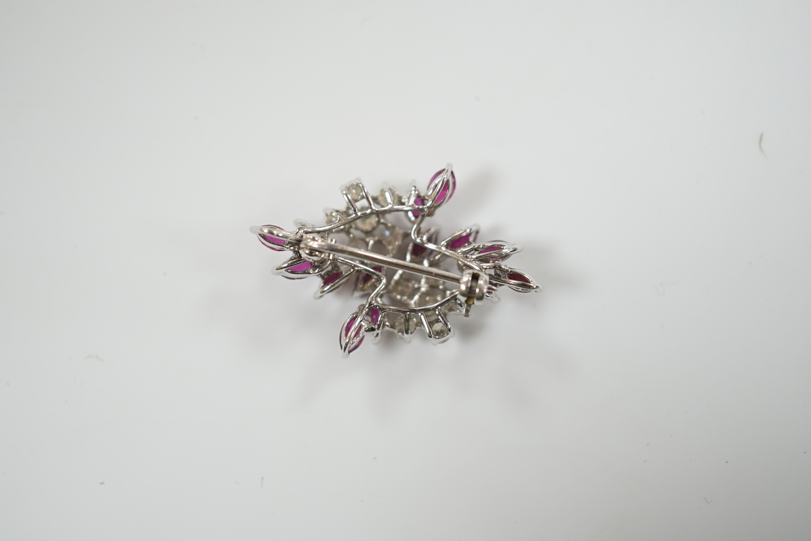 A modern white metal, ruby and diamond cluster set foliate spray pendant brooch, 32mm, gross weight 5.4 grams.